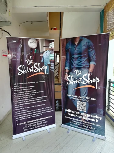 Two luxury standees for The Shirt Shop featuring fashion visuals and franchise branding – created by Acme Advertising Co. for retail display.